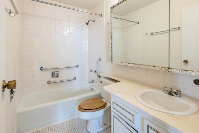 full bathroom with decorative backsplash, toilet, tiled shower / bath, tile walls, and vanity