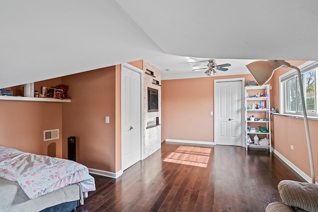 bedroom with dark hardwood / wood-style floors, vaulted ceiling, and ceiling fan