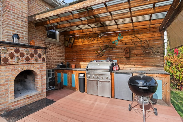 wooden deck featuring an outdoor brick fireplace and area for grilling