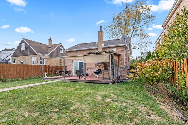 rear view of house featuring a wooden deck and a yard