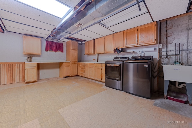 clothes washing area with cabinets and washer and clothes dryer