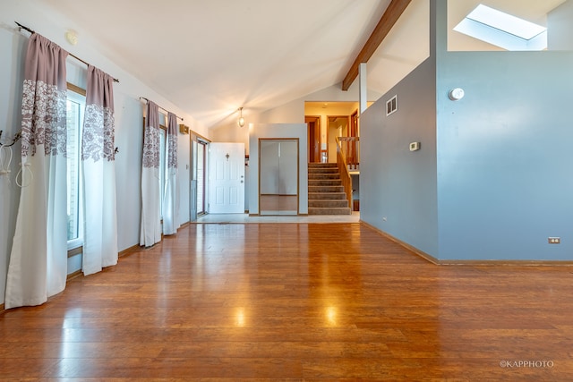 spare room featuring lofted ceiling with skylight and wood-type flooring