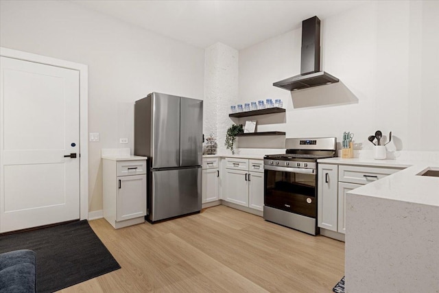 kitchen featuring a peninsula, appliances with stainless steel finishes, light wood-type flooring, wall chimney exhaust hood, and open floor plan