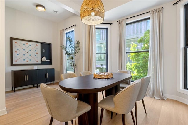 dining area with light wood-type flooring and baseboards