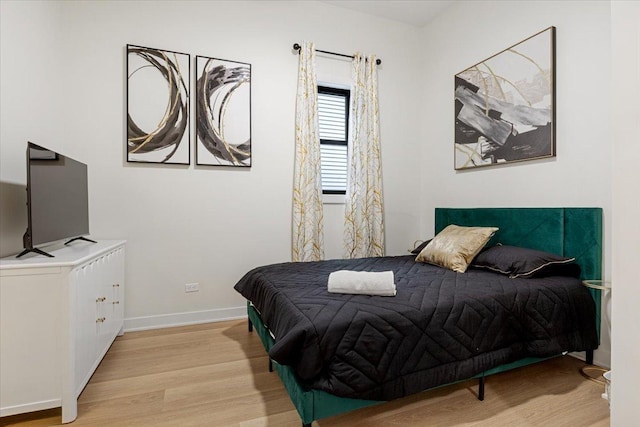 bedroom featuring wood finished floors and baseboards