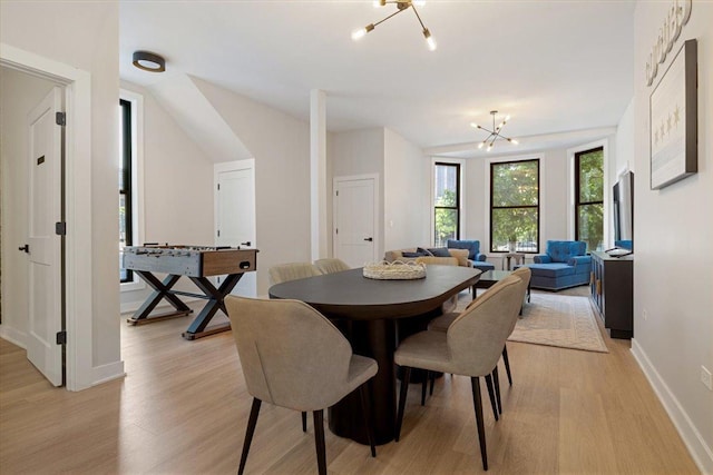 dining space featuring a chandelier, light wood-style flooring, and baseboards