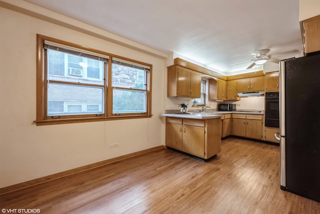 kitchen featuring kitchen peninsula, stainless steel refrigerator, light hardwood / wood-style floors, oven, and ceiling fan