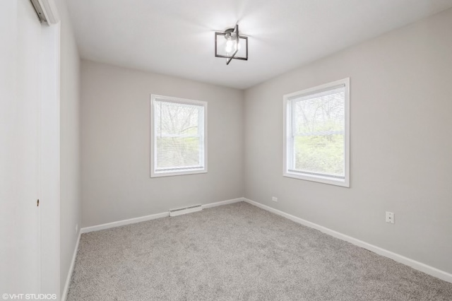 carpeted spare room featuring a healthy amount of sunlight