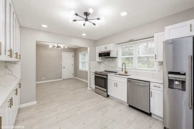 kitchen with white cabinets, appliances with stainless steel finishes, backsplash, and plenty of natural light