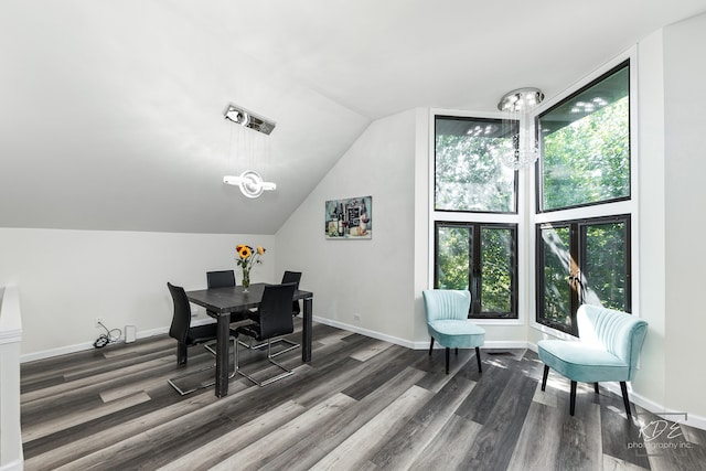 dining area with a notable chandelier, vaulted ceiling, and dark hardwood / wood-style floors