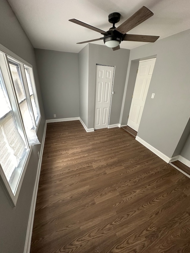 unfurnished bedroom featuring a closet, ceiling fan, and dark hardwood / wood-style flooring