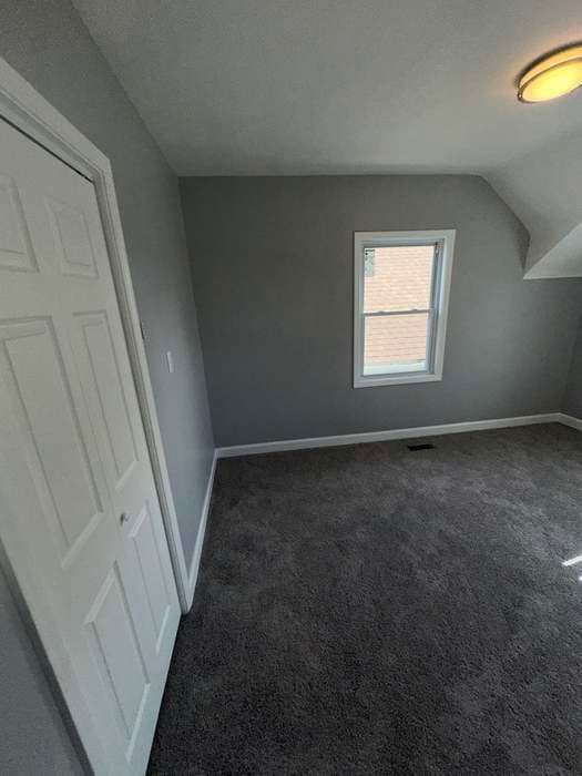 bonus room with a textured ceiling, dark carpet, and lofted ceiling