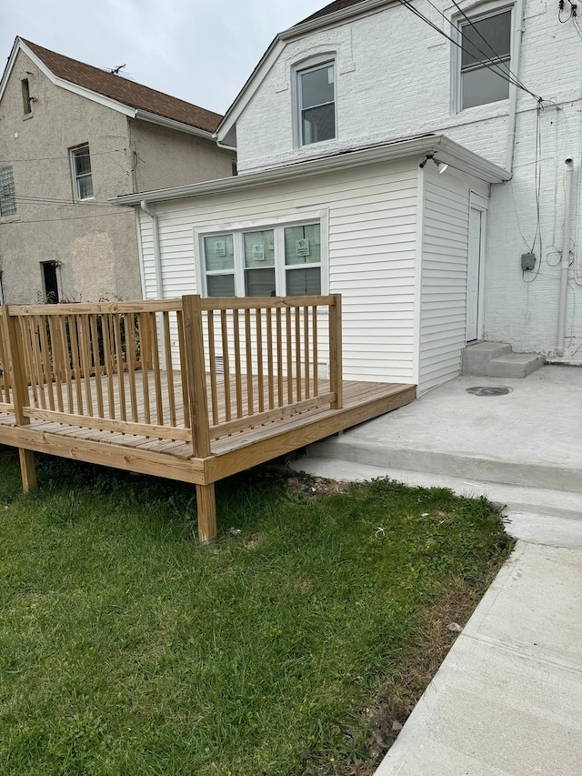 rear view of house featuring a lawn and a wooden deck