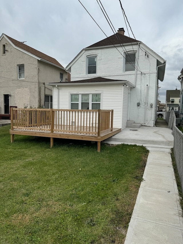 back of property with a yard and a wooden deck