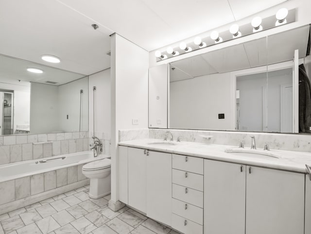 bathroom featuring vanity, toilet, and a relaxing tiled tub