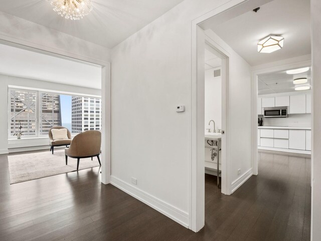 161 E Chicago Ave Unit 42H, Chicago, IL 60611 - hallway featuring dark wood-style flooring and a chandelier