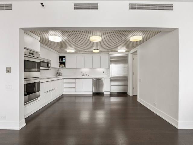 kitchen featuring white cabinetry, stainless steel appliances, dark wood-type flooring, and sink