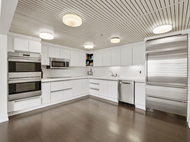 kitchen with sink, white cabinets, stainless steel appliances, and dark hardwood / wood-style floors