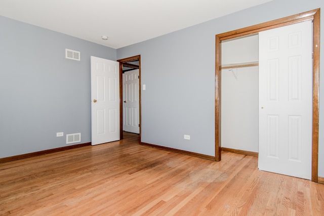 unfurnished bedroom featuring light hardwood / wood-style floors and a closet