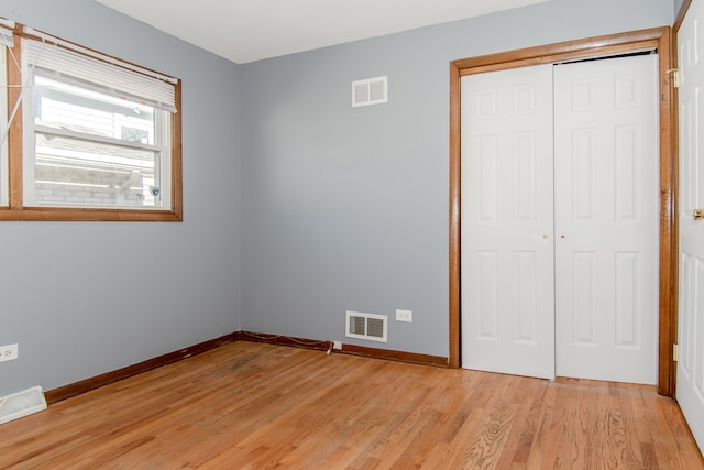 unfurnished bedroom with light hardwood / wood-style floors and a closet