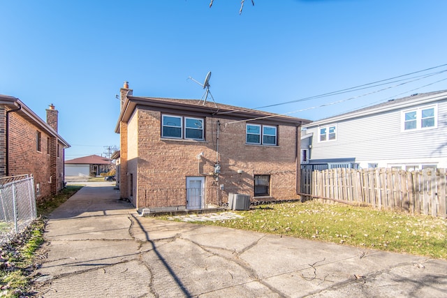 rear view of property with central AC