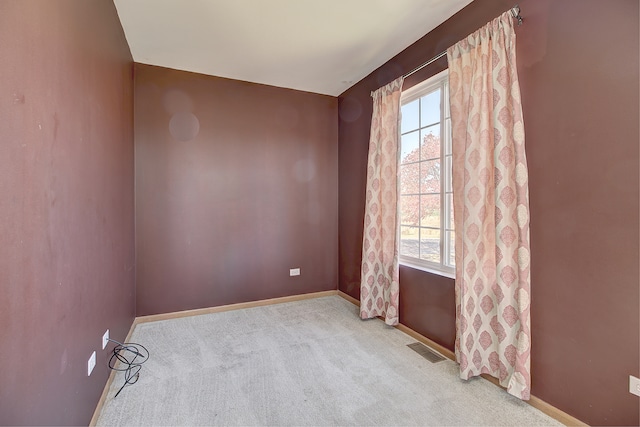 unfurnished room featuring light carpet