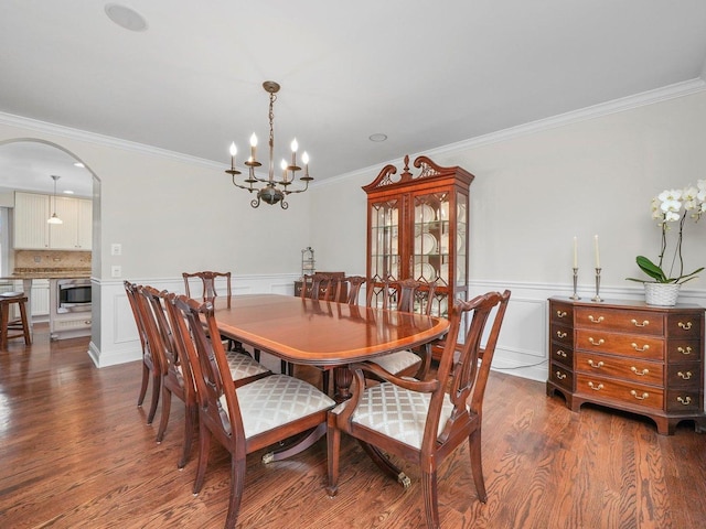 dining area with dark hardwood / wood-style flooring, a notable chandelier, and ornamental molding