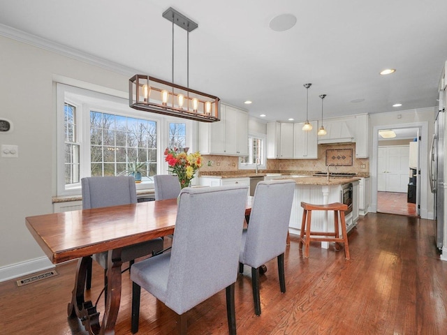 dining room with a chandelier, dark hardwood / wood-style flooring, and ornamental molding