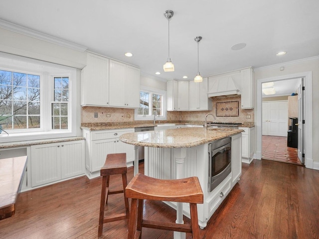 kitchen featuring white cabinetry, dark wood-type flooring, an island with sink, and stainless steel appliances