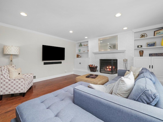 living room with ornamental molding, dark wood-type flooring, built in features, and a brick fireplace