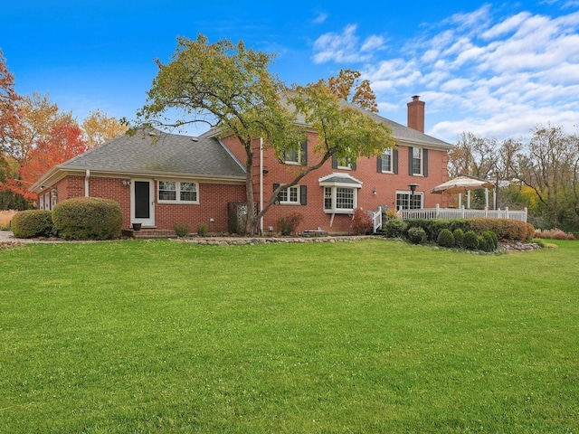 rear view of house featuring a yard