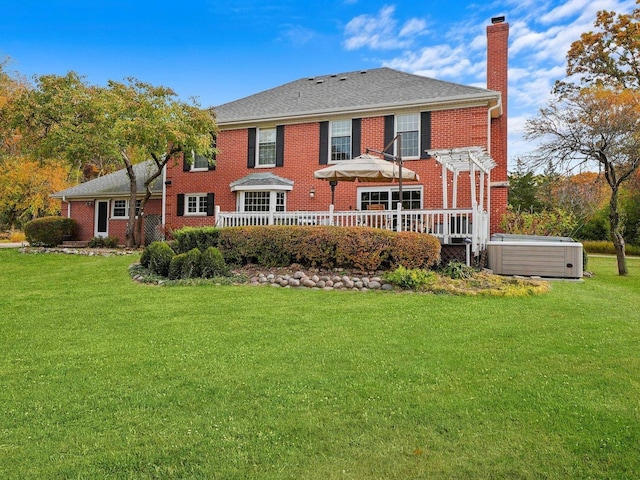 back of house featuring a pergola, a hot tub, a lawn, and a wooden deck