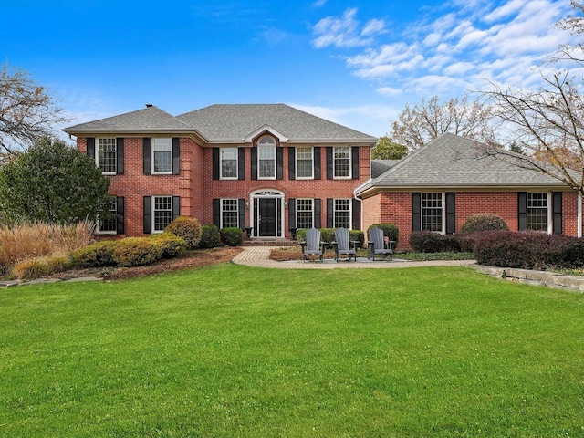 colonial-style house featuring a front yard