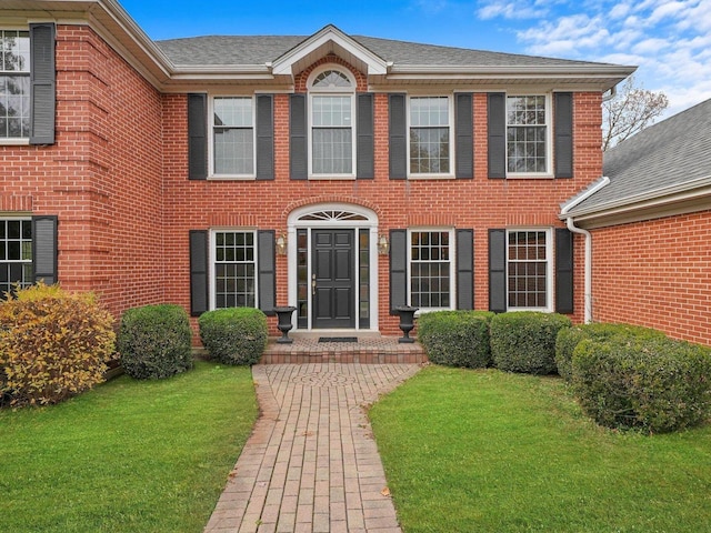 colonial home featuring a front lawn