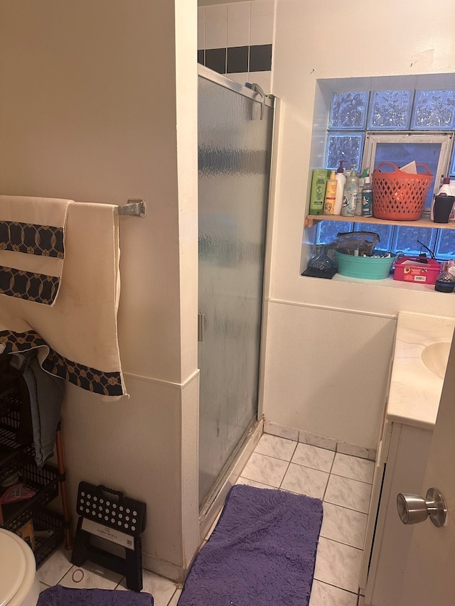 bathroom with vanity, walk in shower, toilet, and tile patterned flooring