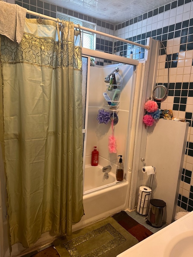 bathroom featuring a textured ceiling, tile walls, and shower / tub combo