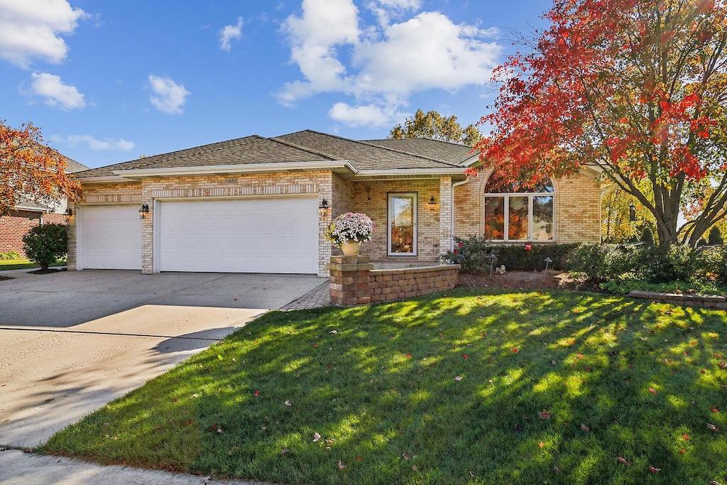 view of front of house with a garage and a front lawn