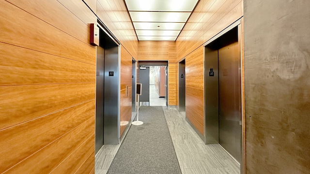 hall featuring wooden walls and elevator