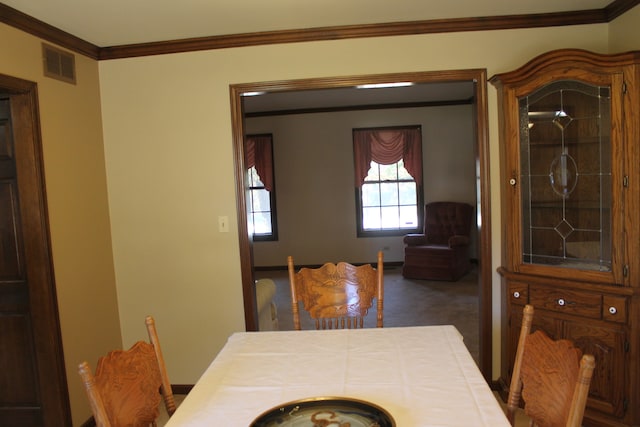 dining space featuring crown molding and carpet floors