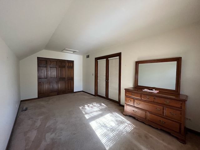 unfurnished bedroom featuring french doors, carpet, and vaulted ceiling