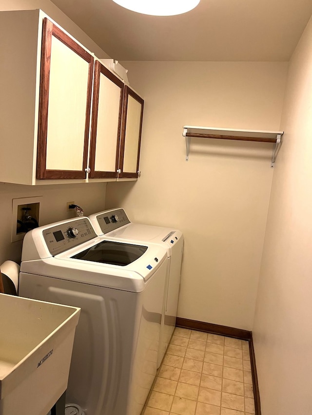 laundry area with cabinets, sink, washing machine and clothes dryer, and light tile patterned floors