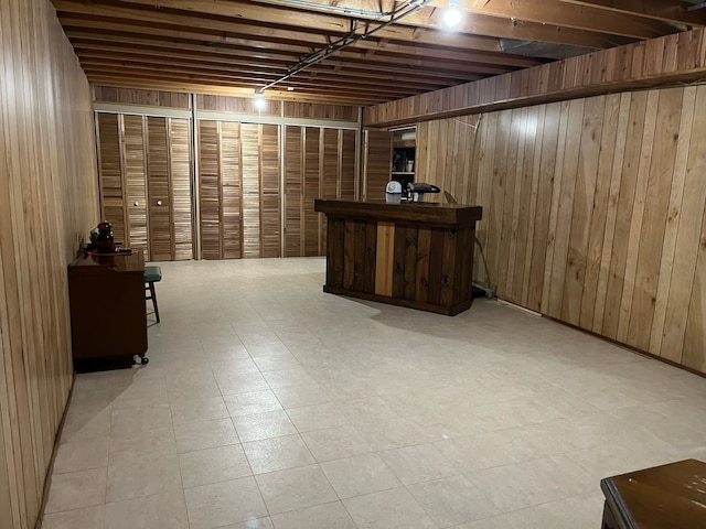 basement featuring bar area and wooden walls