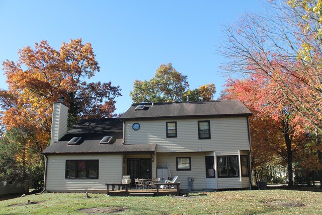 rear view of house featuring a yard and a wooden deck