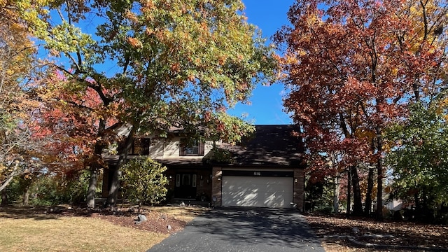 view of property hidden behind natural elements with a garage