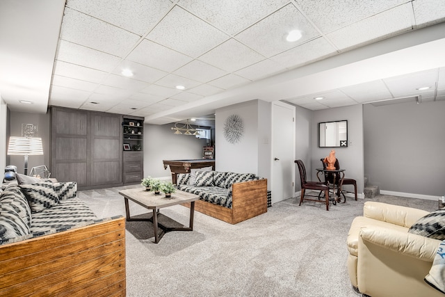 carpeted living room with a paneled ceiling and billiards