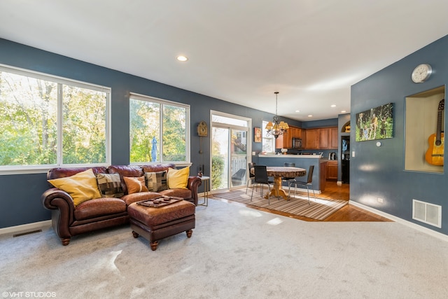 living room featuring a chandelier and light wood-type flooring