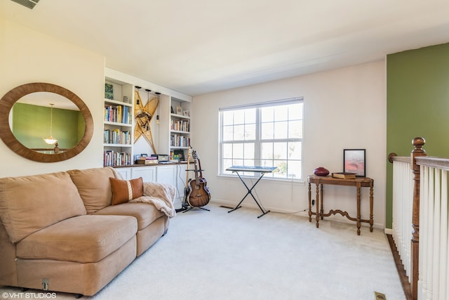 sitting room featuring light carpet and built in features