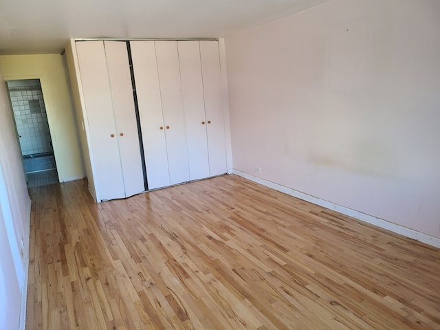 unfurnished bedroom featuring a closet and light hardwood / wood-style flooring