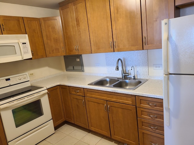 kitchen featuring sink, white appliances, and light tile patterned floors