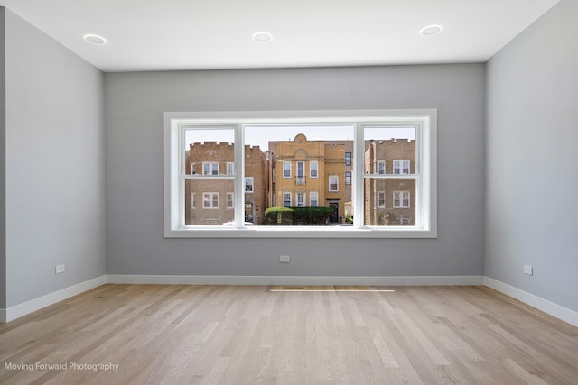 empty room with a wealth of natural light and light hardwood / wood-style floors